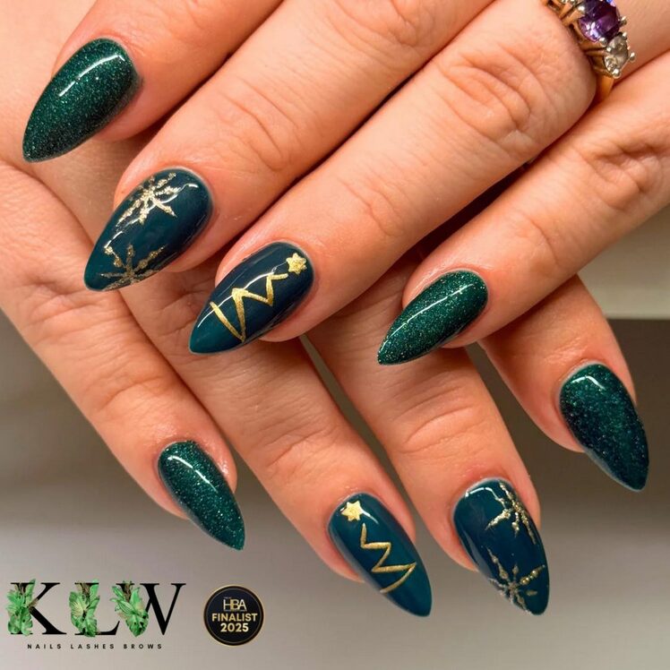 Rich emerald green nails with shimmering gold foil accents