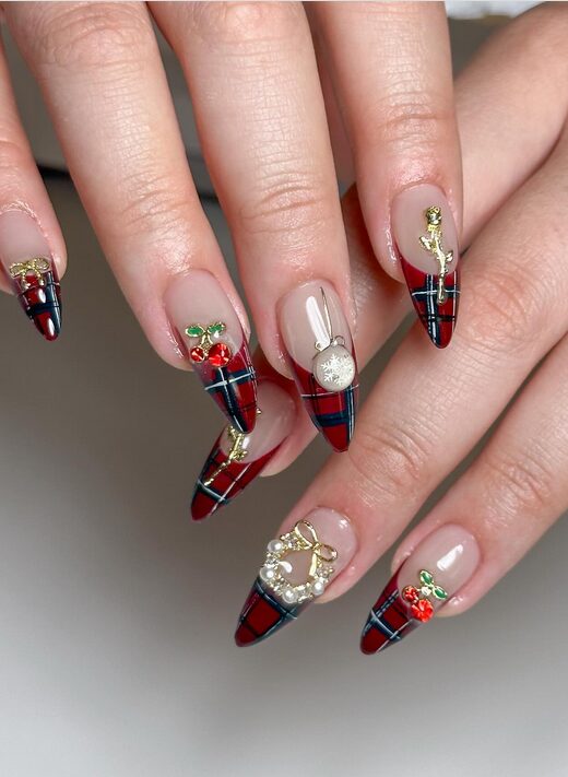 Festive red and green plaid nails with white snowflake accents