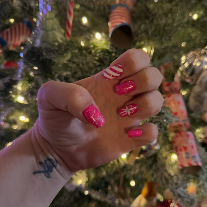 manicure in crisp white base with shimmering silver foil accents and delicate snowflake detailing