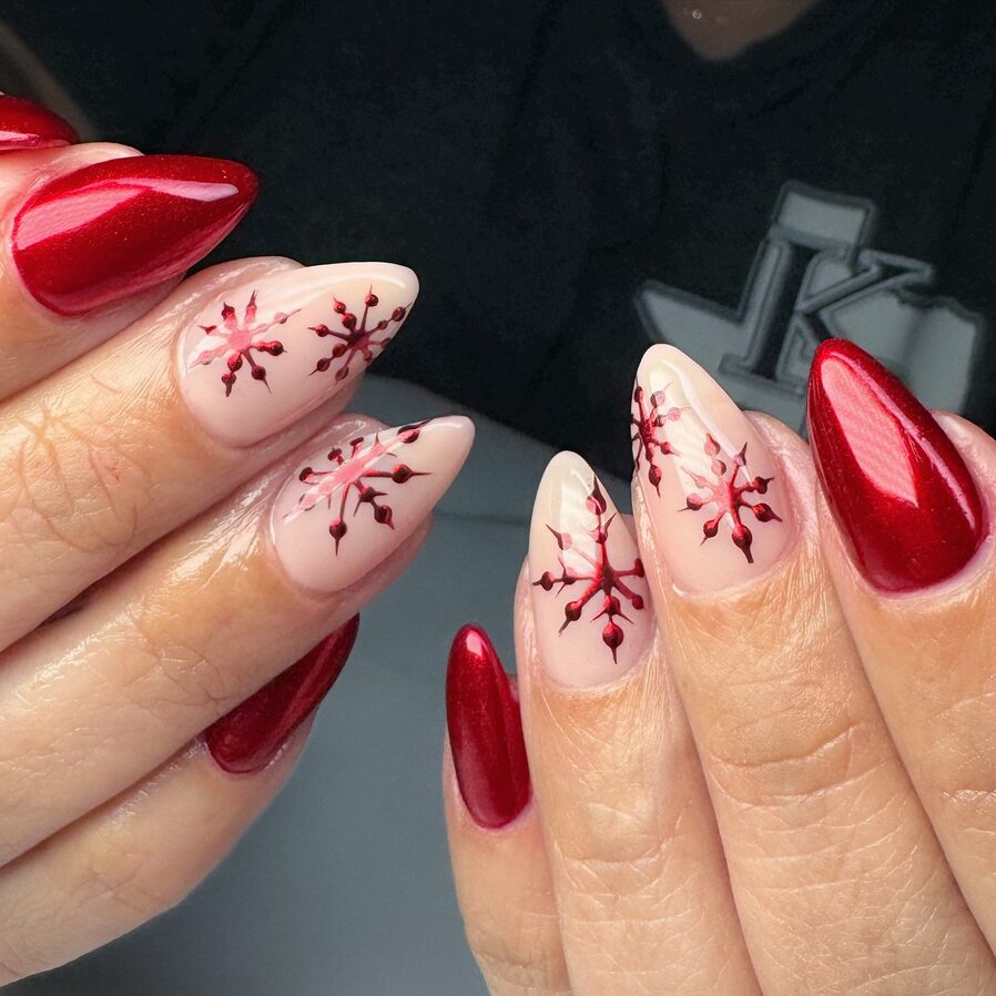 Bright red nails with white snowflake nail art for a festive holiday manicure