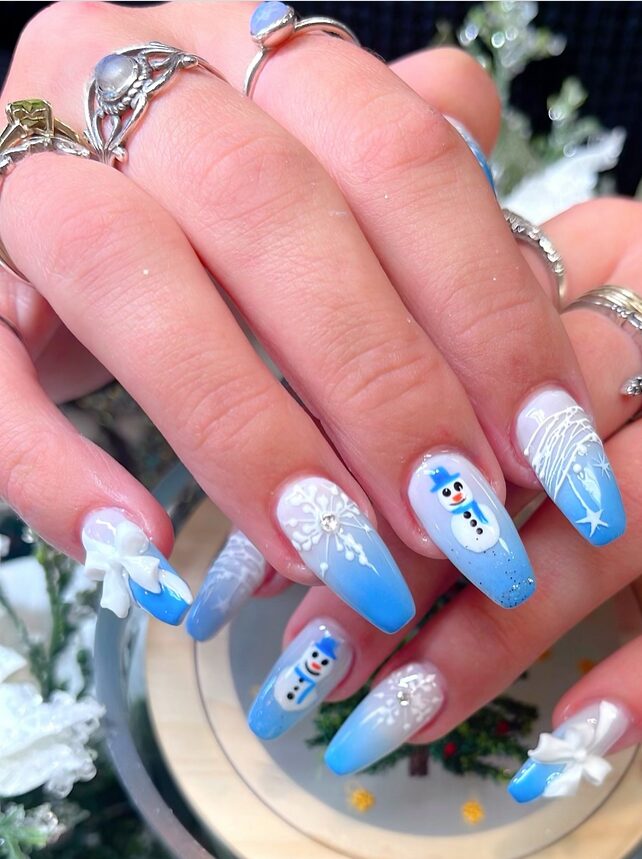 Blue-to-white ombre nails featuring snowmen