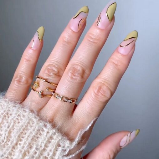 green nails with accent nails wrapped in gold foil