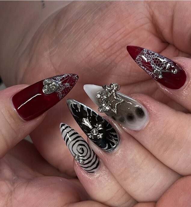 Free-style grunge nails with dark tones, metallic accents, and abstract messy designs