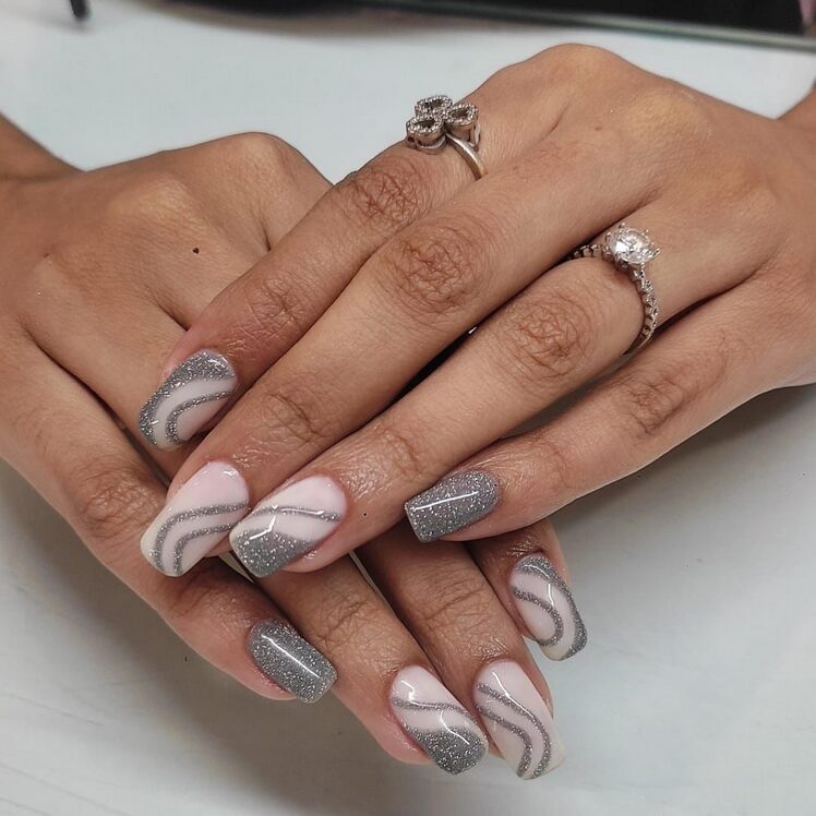 Grey nails with white and silver swirl nail art.