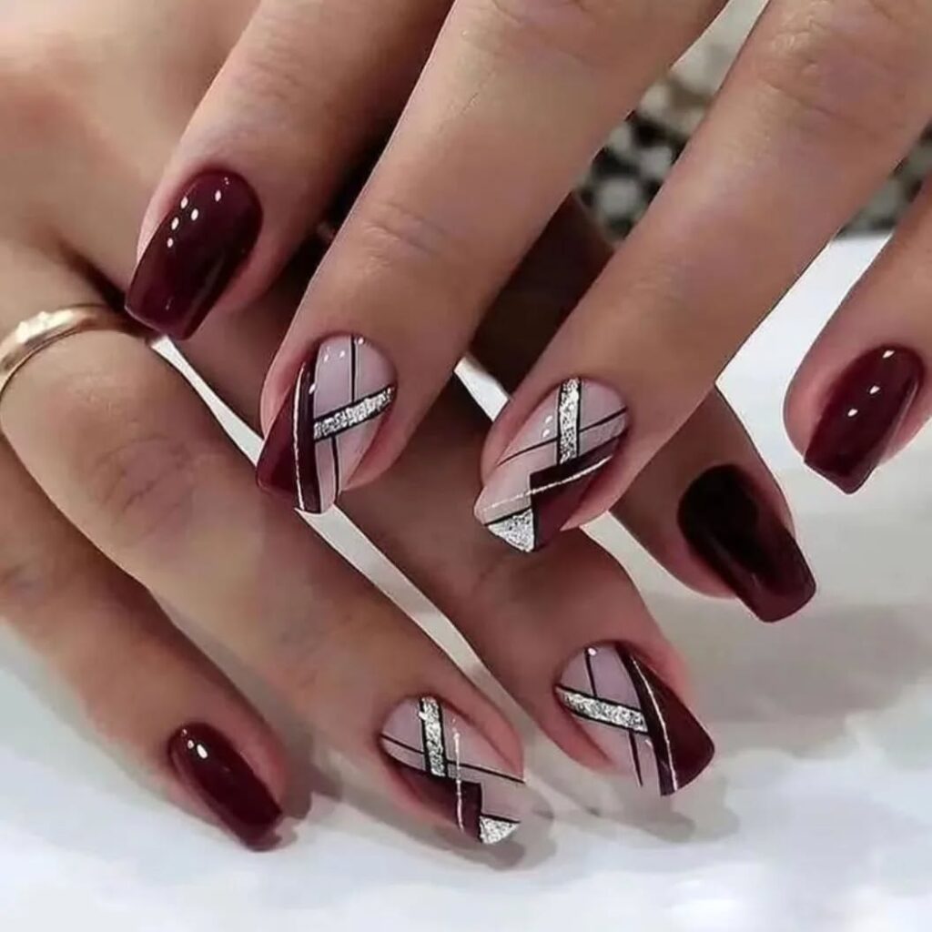 Dark burgundy and nude nails with geometric golden glitter