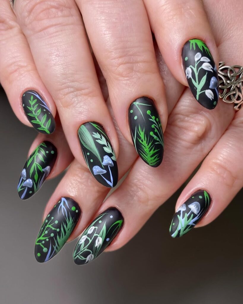 Dark black nails with green leaves and white wildflowers
