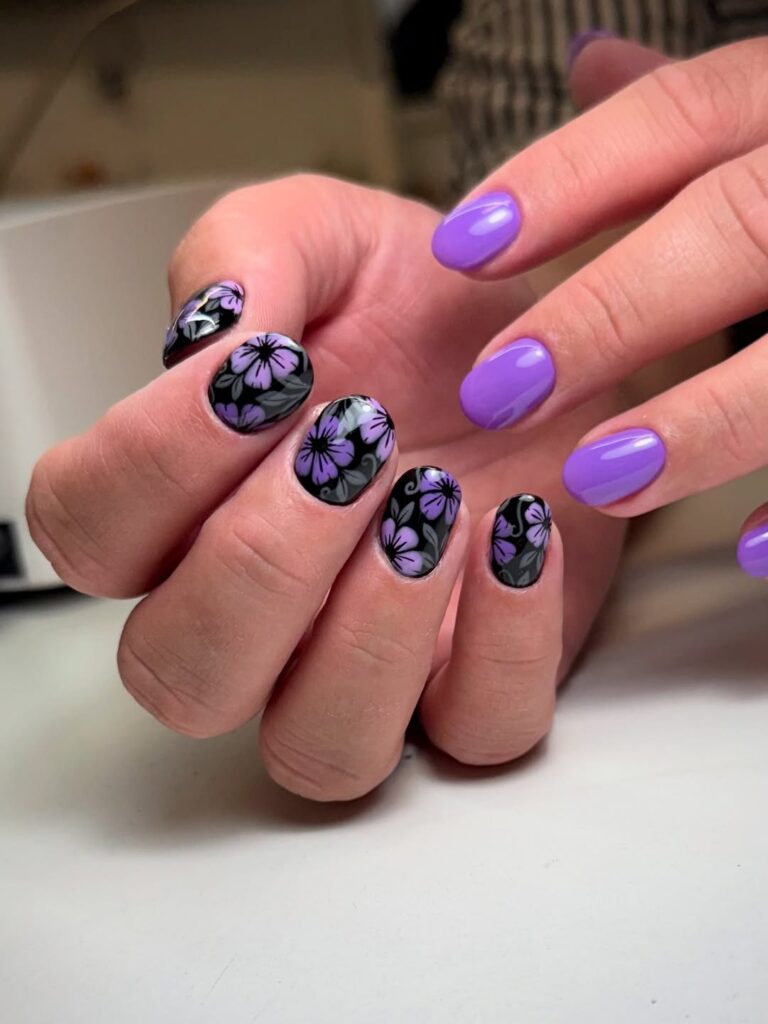 Black nails with purple hibiscus flowers and solid purple accent
