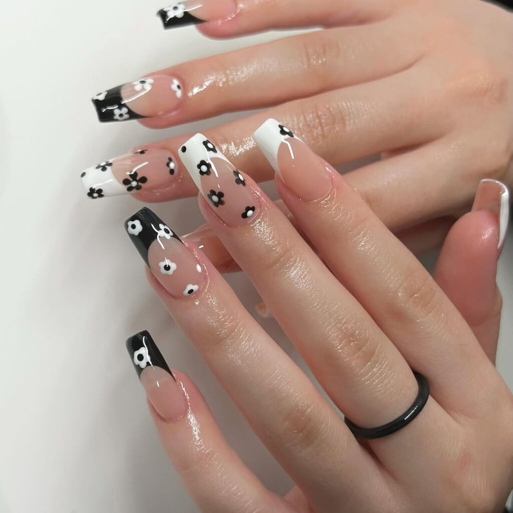 Long coffin nails with black and white French tips and daisy flowers