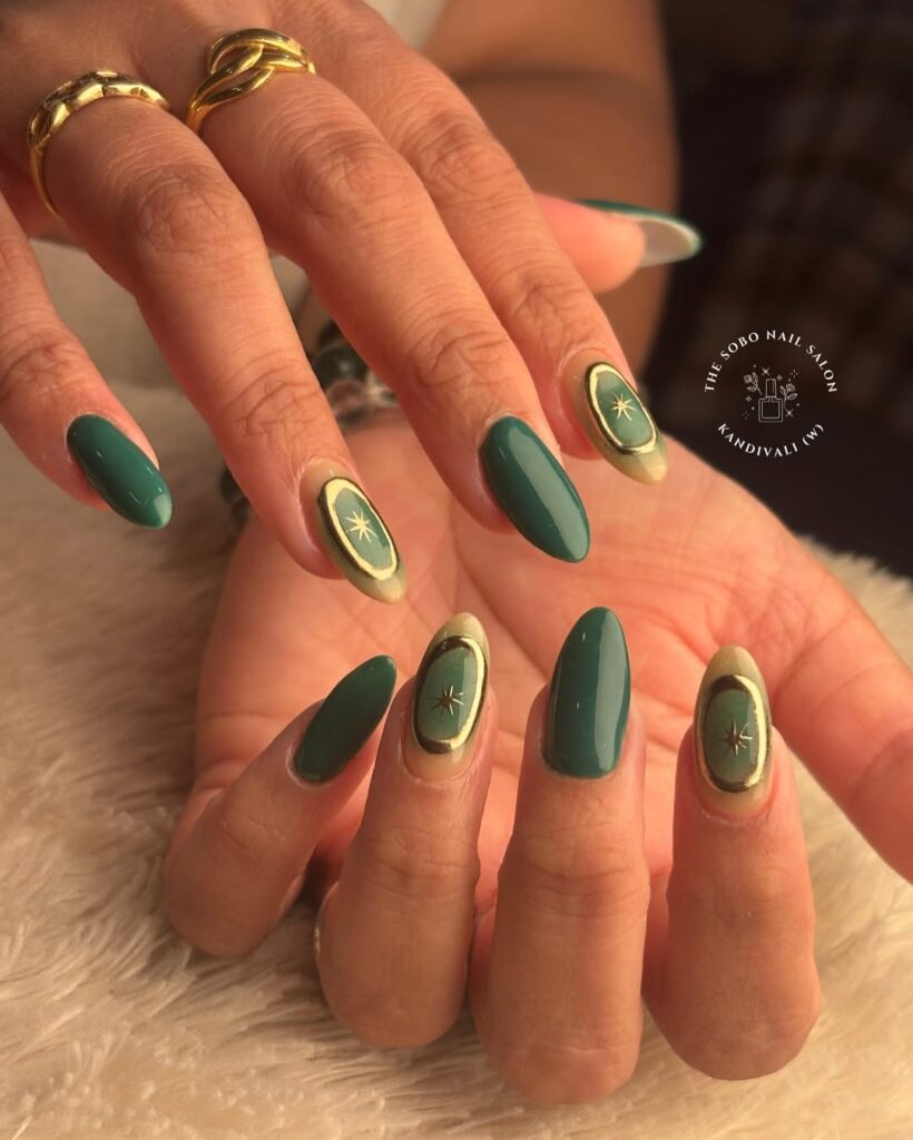 oval nails in deep emerald green with gold and starburst