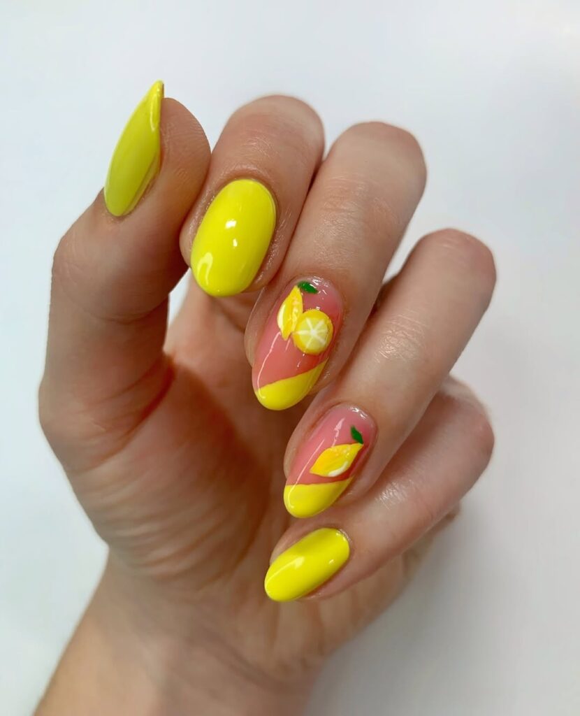 short oval nails in bright yellow with lemon slice nail art