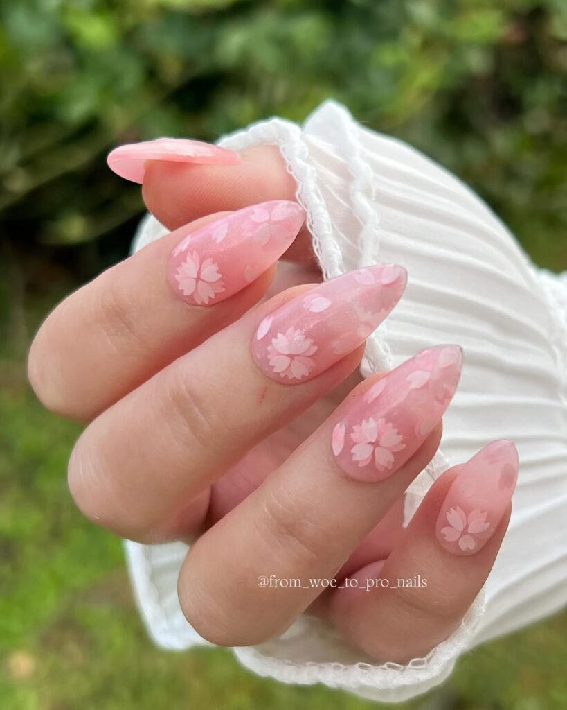 soft pink nails with subtle white floral patterns