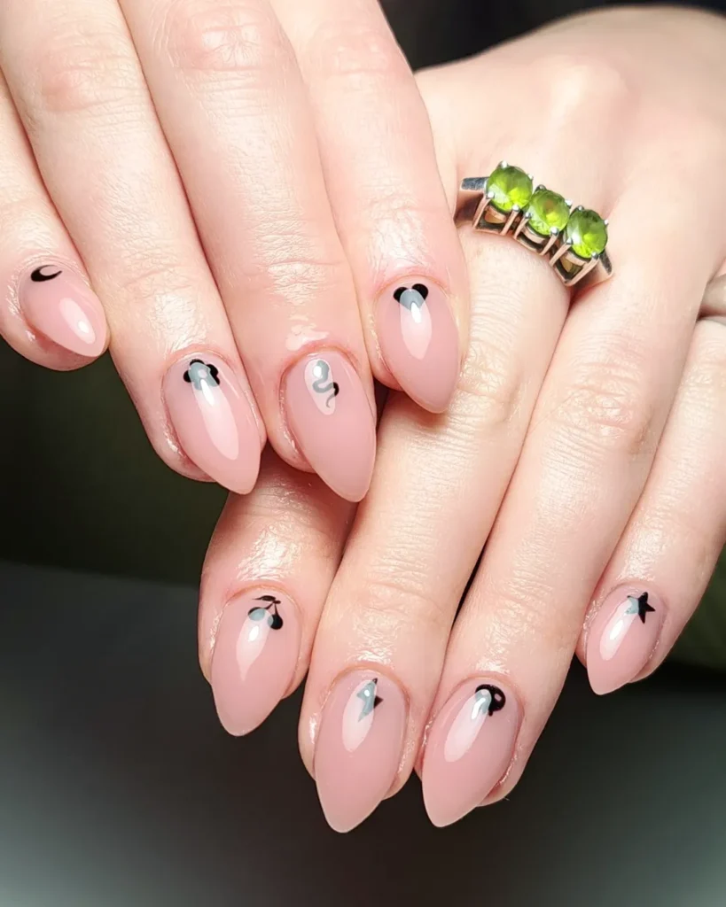 Nude almond nails with tiny black moon cherry snake and star details