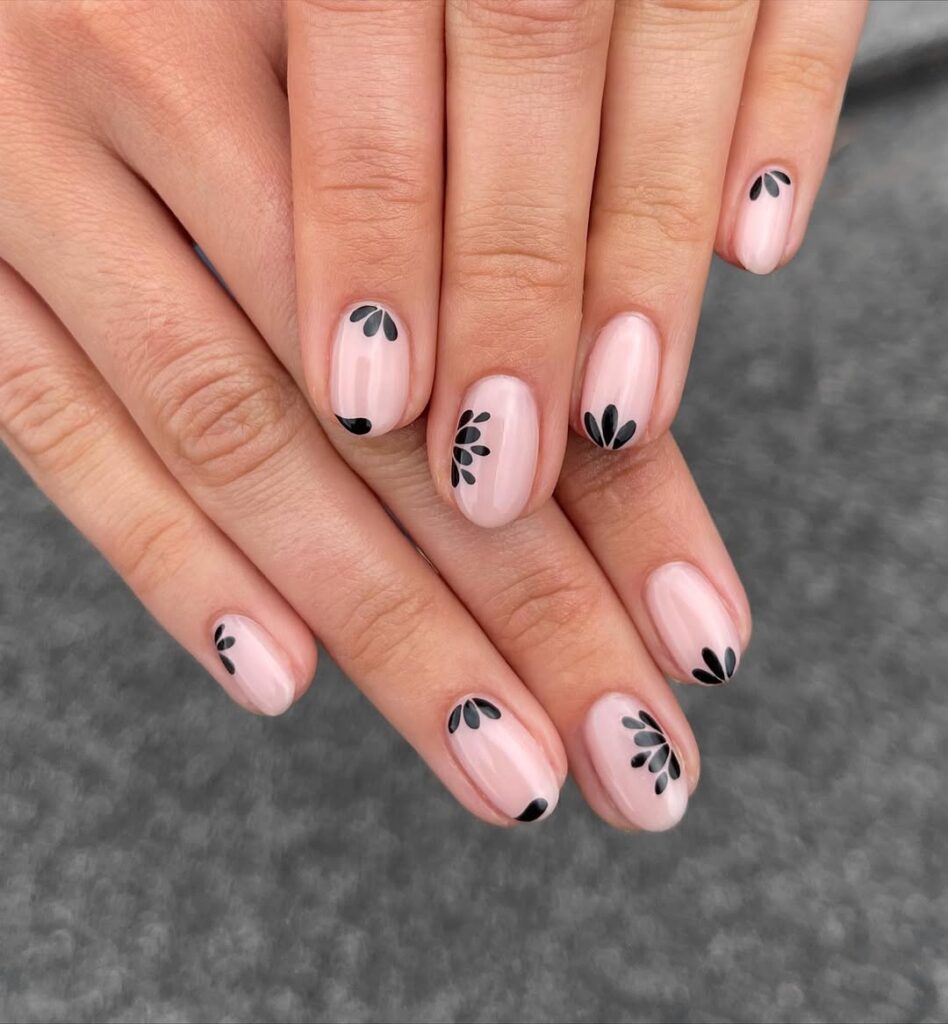 Soft pink nude nails with delicate black leaf petals