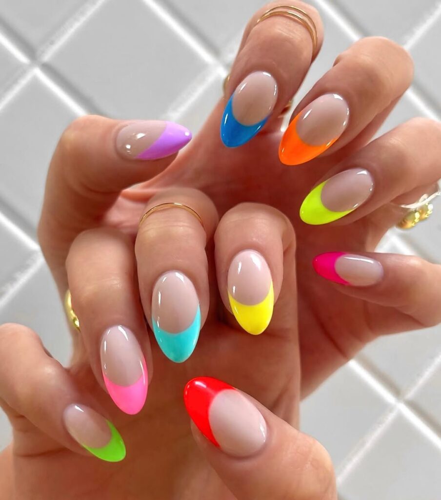 nails with glossy neon rainbow French tips on nude base