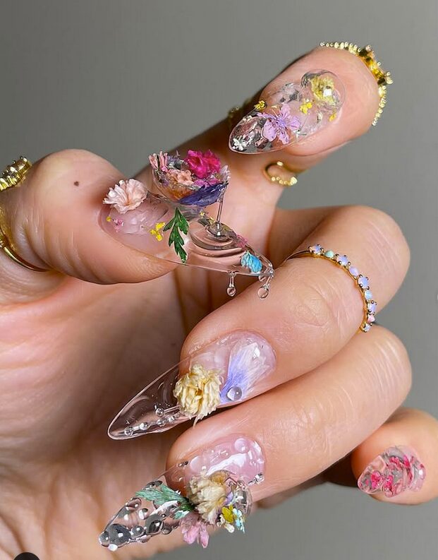 3D nails decorated with dried flowers, resin details, and sculpted art