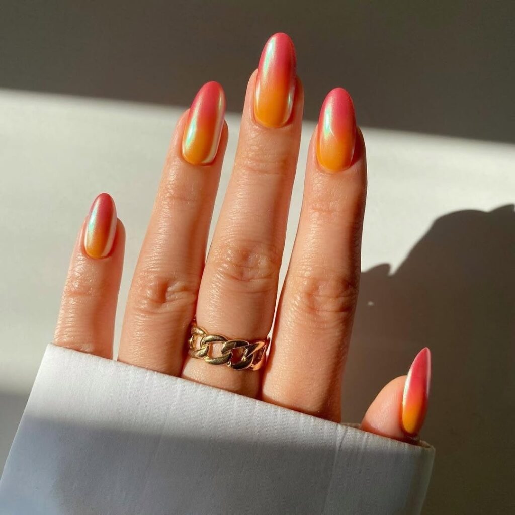 nails in warm coral and orange chrome with iridescent finish