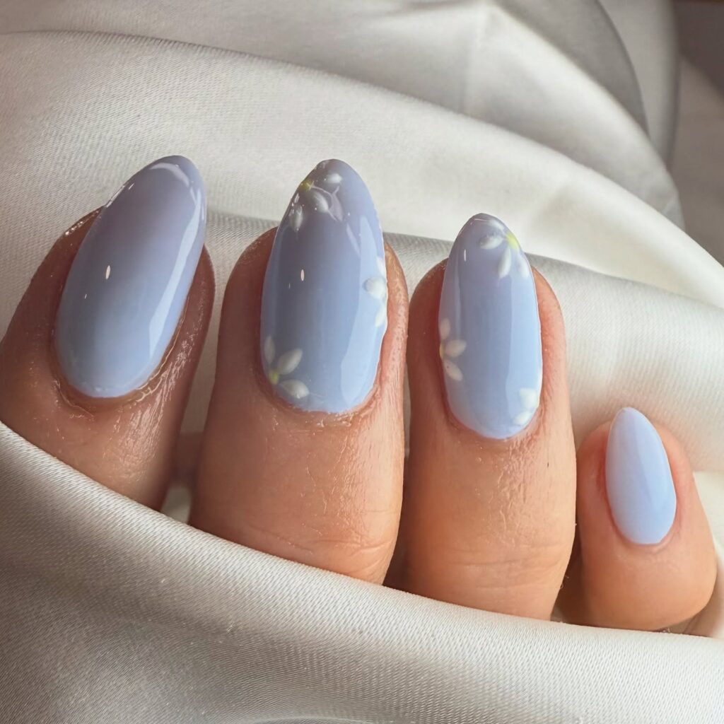 nails with solid dusty blue polish and subtle white cherry blossom petals