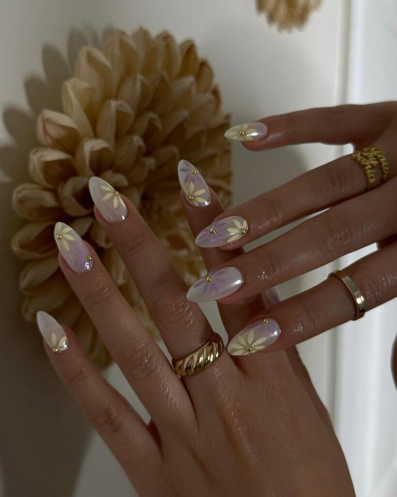 Long almond nails with iridescent pearl chrome and gold-centred daisy nail art