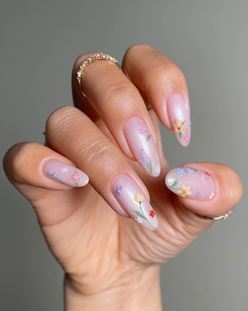 nails with iridescent shimmer base and painted wildflowers in pink, blue, yellow