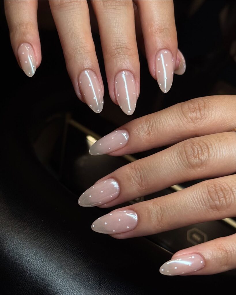 nails with sheer nude base and scattered tiny white dots like a constellation