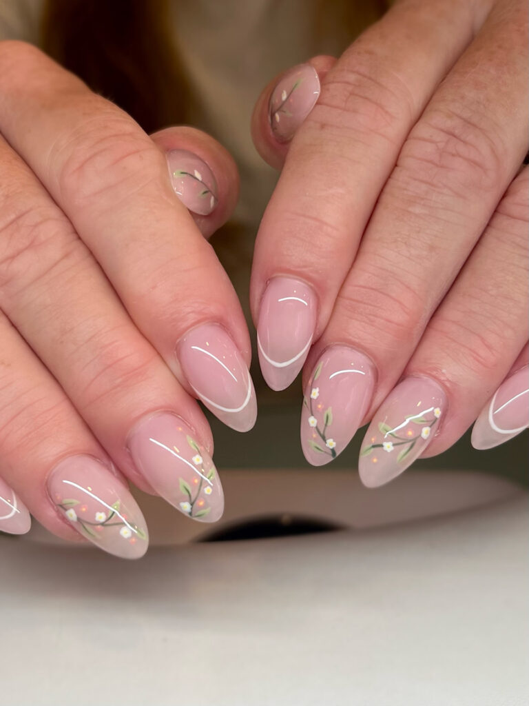 Long almond nails with sheer blush base, white French tips and cherry blossom branch art