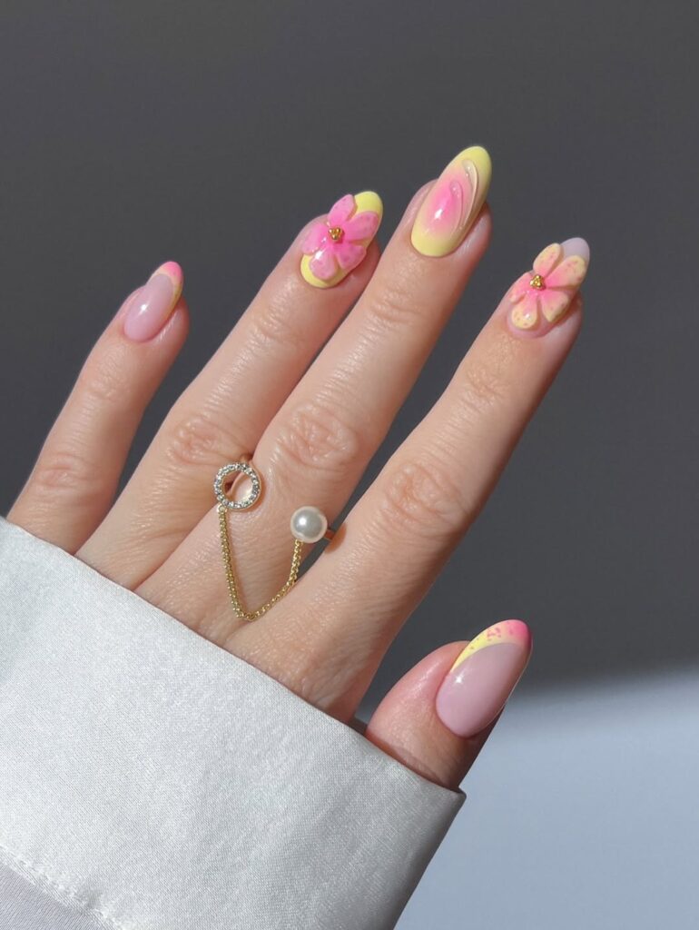 nails with pink and yellow chrome French tips and 3D pink flower accents