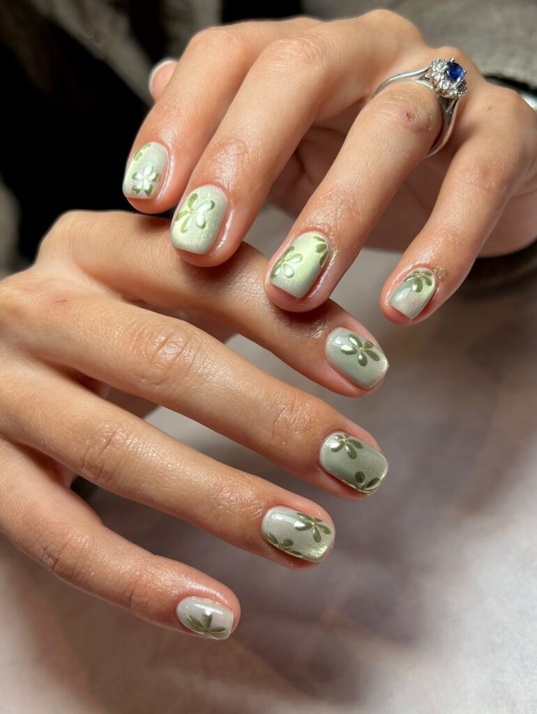 short square nails in sage green chrome with tonal green floral nail art