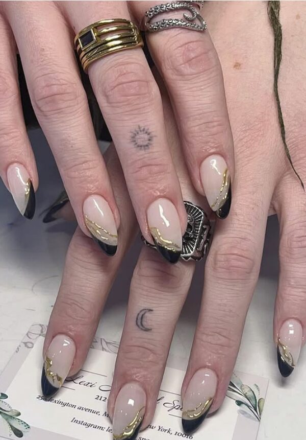 nails with nude bases, black chrome French tips, and fine gold detailing
