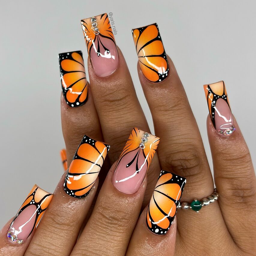 Square nails with bright orange monarch butterfly wing designs