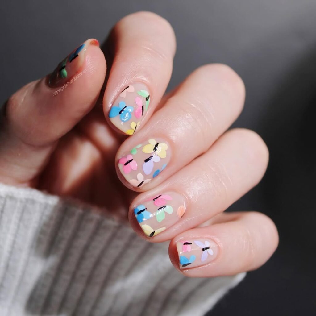 Delicate butterfly nail art on pastel base