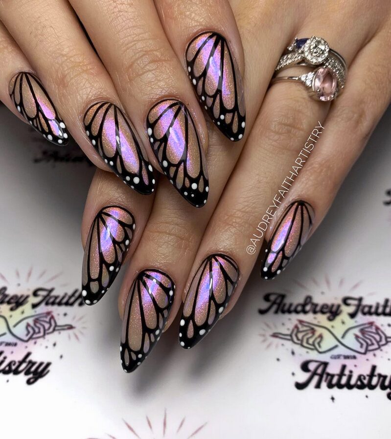 Iridescent nails designed to look like detailed black butterfly wings