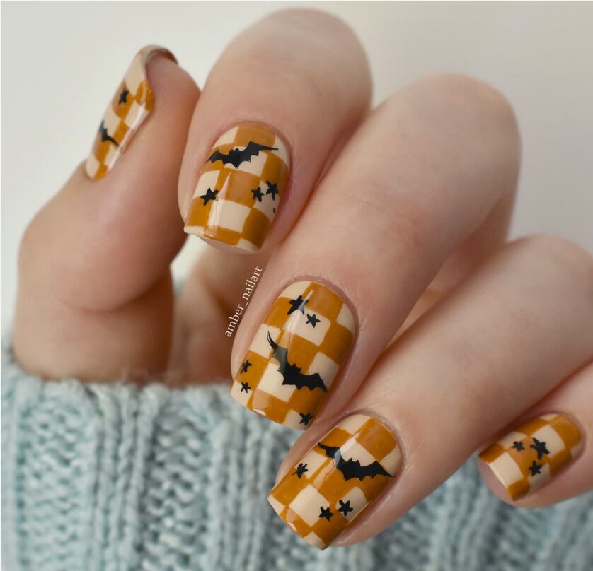 heckerboard caramel and cream nails with black bat and star designs