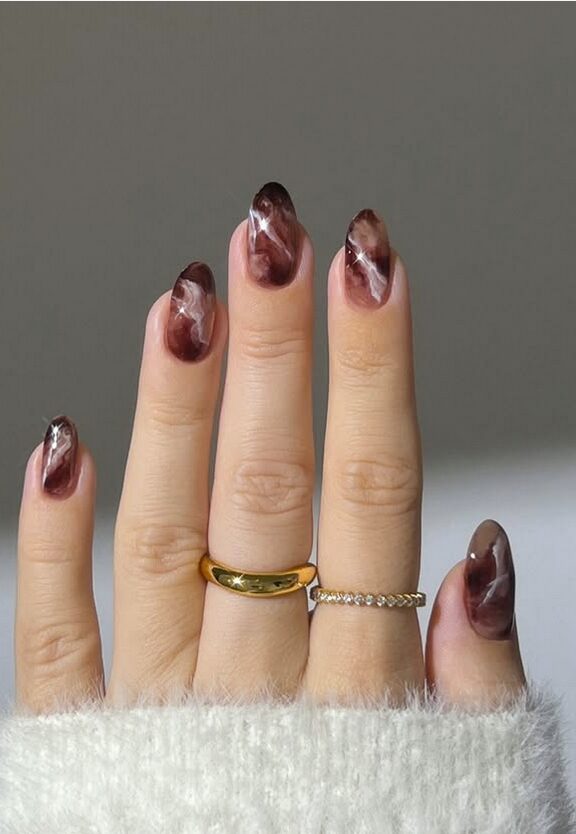 Chocolate brown marble nails with white swirling accents