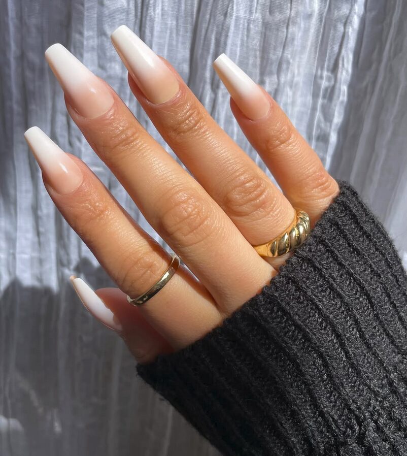 nude ombre nails with a soft white fade, featuring long square tips and a glossy finish