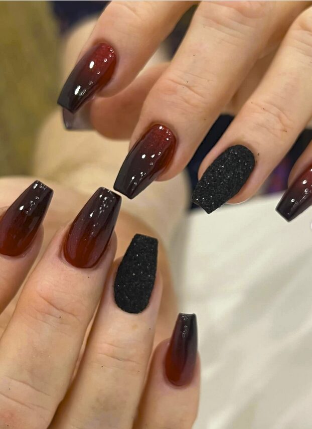 nails featuring a glossy red-to-black ombré design with textured matte black accent nails