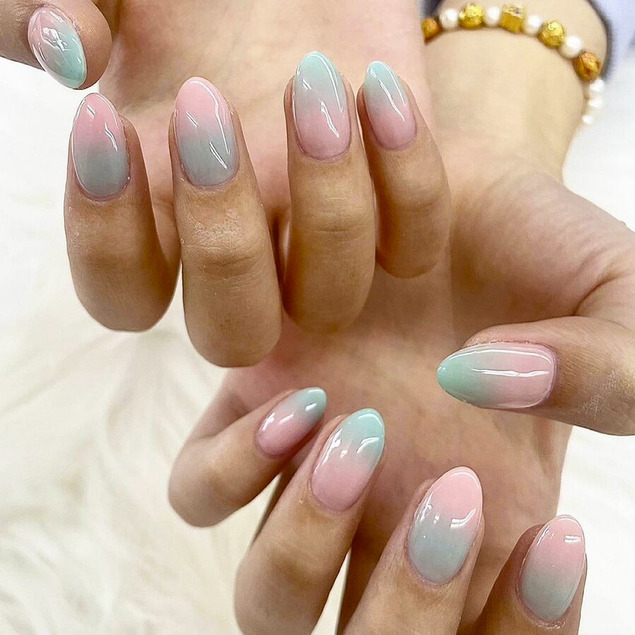 Soft pink and mint green ombre nails with a glossy finish