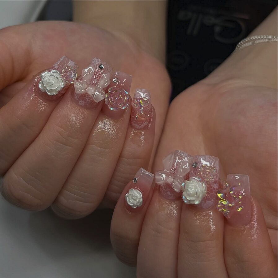 Pink nails with 3D roses, crystal details, and layered jelly textures