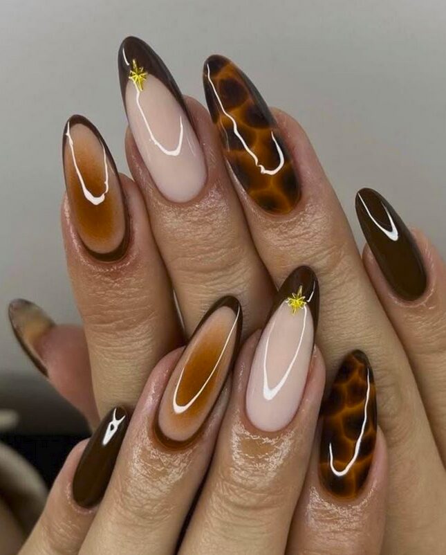 caramel and brown tortoise-shell nails mixed with nude accents and small gold star details