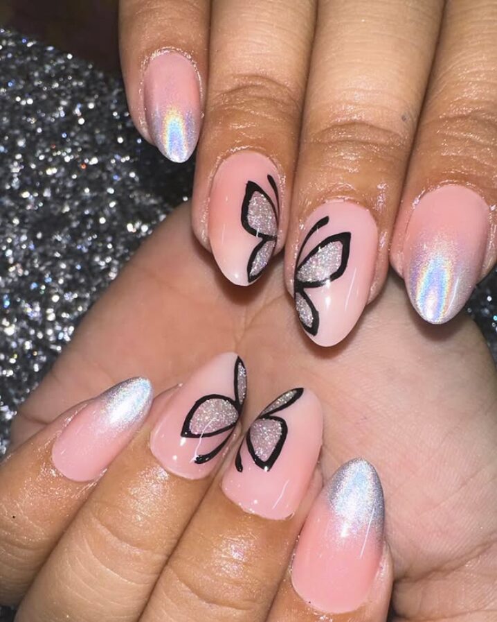 Pink nails with holographic tips and silver butterfly wing accents