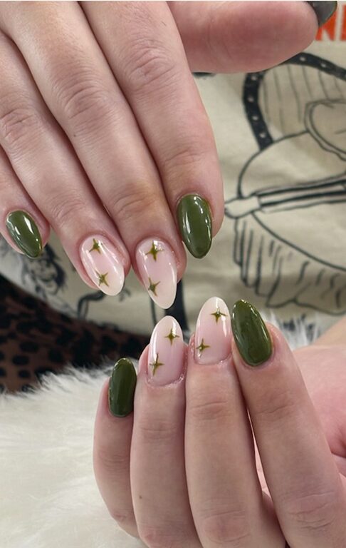 Olive green nails paired with nude nails featuring small gold star accents