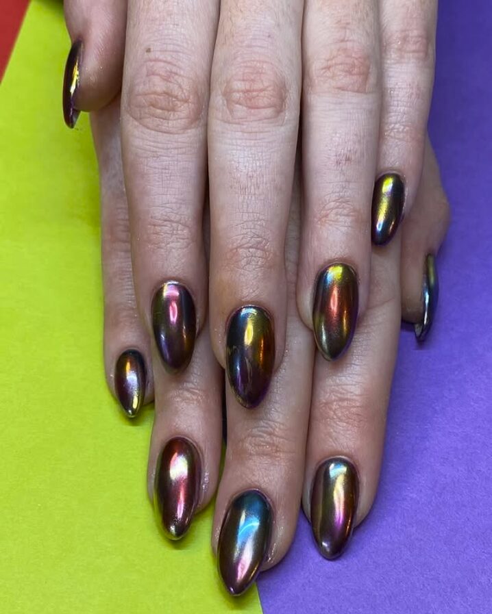 nails with an oil-slick chrome finish showing iridescent tones of purple, gold, and green