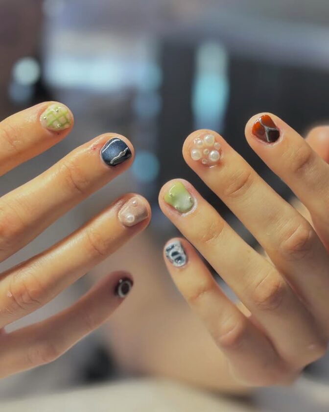 nails with mixed 3D designs, including pearls, abstract patterns