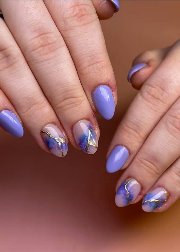 Periwinkle nails with watercolor accents and gold detailing