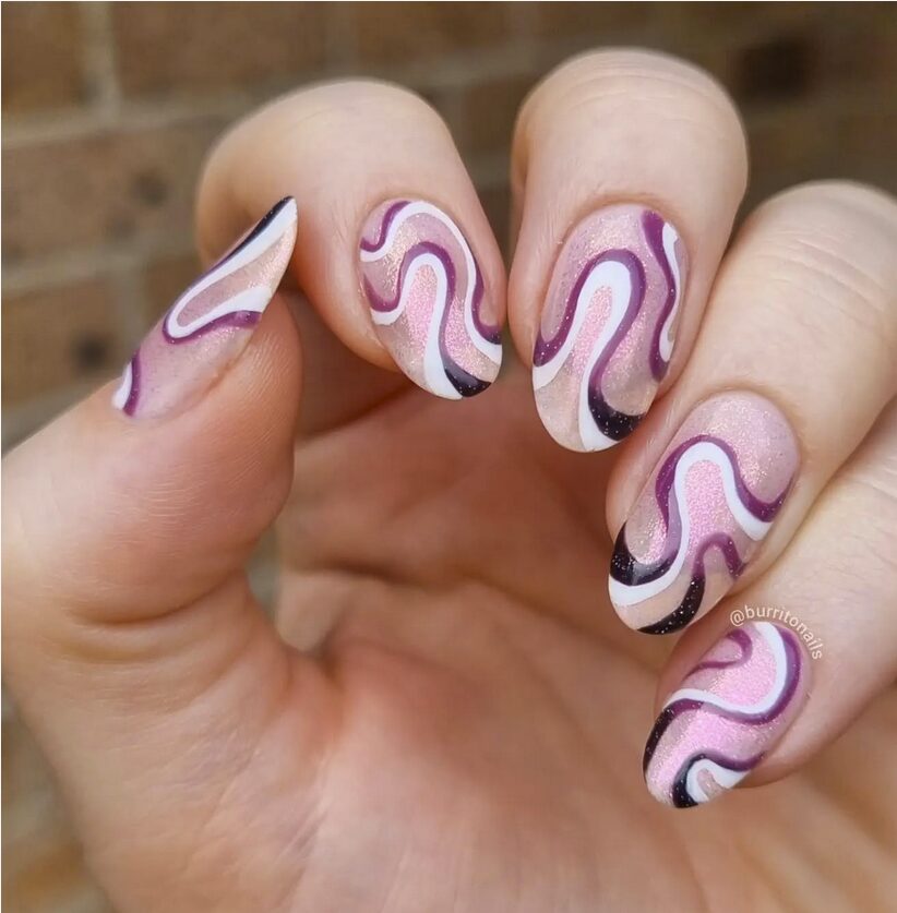 Pink shimmer nails with purple, white, and black wavy swirl designs