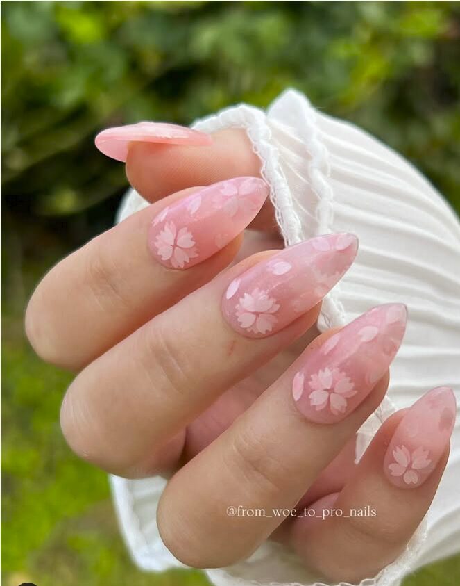 Soft pink nails with delicate sakura (cherry blossom) designs