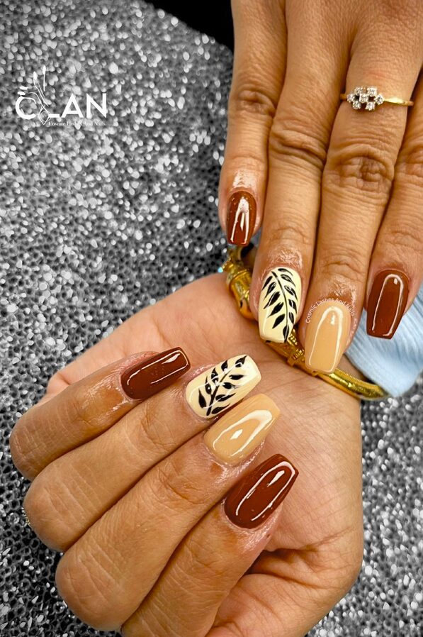 Brown and beige square nails with black leaf accents