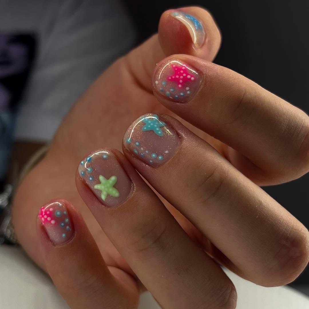 nude nails with colorful starfish designs and tiny dot accents