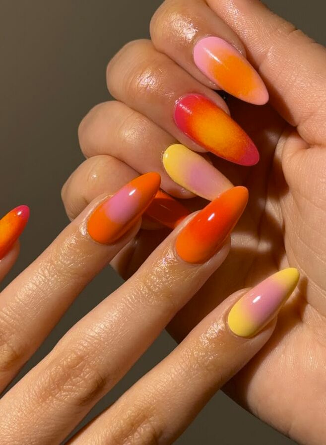 nails with a glossy gradient of orange, pink, yellow, and red