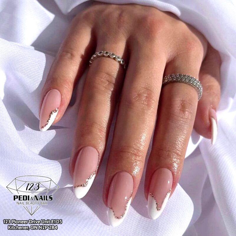 Nails with uneven French tips creating an intentionally mismatched