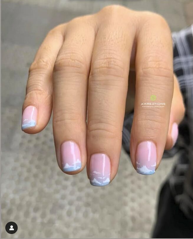 Short pink nails with soft blue cloud-like tips